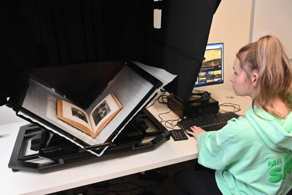a student operating a large book scanner